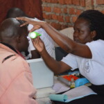 TBF doctor checks a man's eyes