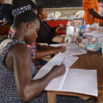 woman registers people at the health care clinic